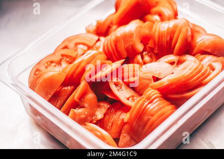 Tomatenbecher in einem Behälter auf dem Küchentisch im Café Stockfoto
