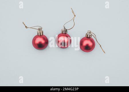 Weihnachtskugeln auf weißem Hintergrund, drei rote Kugeln Stockfoto