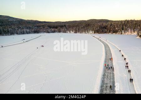 Oslo 20221218. In Sognsvann hat die Gemeinde das Eis gemessen, um sicher zu sein, und hat vor kurzem einen zwei Kilometer langen Skateboard-Pfad gepflügt. Hier vom 4. Adventsfall. Foto: Heiko Junge / NTB Stockfoto