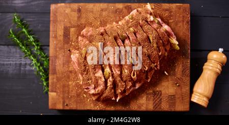 Fleisch mit Gewürzen, fertig zum Backen im Ofen. Ich koche Fleisch Stockfoto