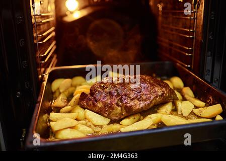 Hausgemachte Speisen in einem Elektroofen zubereiten. Gemüseeintopf mit Kartoffeln, Fleisch. Horizontales Foto. Stockfoto