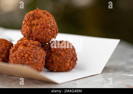 Essenslieferung, Falafel-Essen zum Mitnehmen, Papierbehälter mit Falafel-Kugeln und Sauce. Menü, Nahaufnahme Stockfoto