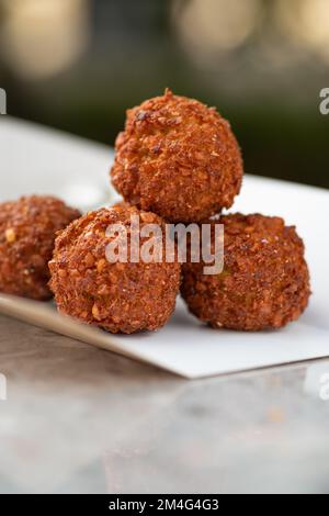 Essenslieferung, Falafel-Essen zum Mitnehmen, Papierbehälter mit Falafel-Kugeln und Sauce. Menü, Nahaufnahme Stockfoto