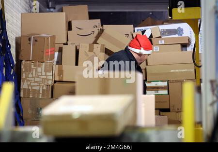 21. Dezember 2022, Mecklenburg-Vorpommern, Groß Schwaß: An der DHL-Lieferstelle wird ein Lkw mit Paketen entladen, die an die Lieferfahrzeuge verteilt werden. An normalen Tagen werden bis zu 6.000 Pakete pro Tag abgewickelt; vor Weihnachten werden bis zu 9.000 Pakete abgewickelt. Foto: Bernd Wüstneck/dpa Stockfoto