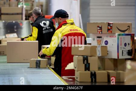 21. Dezember 2022, Mecklenburg-Vorpommern, Groß-Schwaß: An der DHL-Lieferbasis werden die gelieferten Pakete über ein Förderband an die Lieferfahrzeuge weitergeleitet. An normalen Tagen werden bis zu 6.000 Pakete pro Tag abgewickelt; vor Weihnachten werden bis zu 9.000 Pakete abgewickelt. Foto: Bernd Wüstneck/dpa Stockfoto