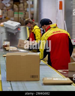 21. Dezember 2022, Mecklenburg-Vorpommern, Groß-Schwaß: An der DHL-Lieferbasis werden die gelieferten Pakete über ein Förderband an die Lieferfahrzeuge weitergeleitet. An normalen Tagen werden bis zu 6.000 Pakete pro Tag abgewickelt; vor Weihnachten werden bis zu 9.000 Pakete abgewickelt. Foto: Bernd Wüstneck/dpa Stockfoto