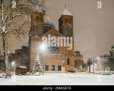 Katholische Kirche Eglise Saint-Pierre-le-Jeune de Strasbourg bei Nacht während eines Schneesturms - Besichtigung des Elsass, Straßburg Frankreich Stockfoto