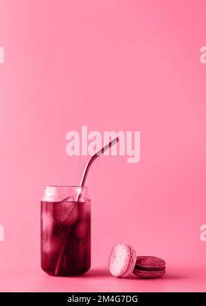 Ein Glas Eiskaffee in einem großen Glas mit Creme und Makronen in trendigen magentafarbenen Farben des Jahres 2023. Speisekonzept. Speicherplatz kopieren. Nahaufnahme. Stockfoto