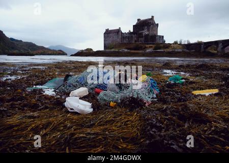 Schottland, Großbritannien. 15.. September 2021 Ocean Rebellion eine Schwestergruppe, die Rebellion auslöscht, inszeniert eine Theateraktion vor dem Schloss Eilan Donan, die sich als tote Meerjungfrauen ausgibt, die von Fischnetzen gefangen werden, um gegen die Grundschleppnetzfischerei zu protestieren, eine Fangtechnik, die Netze über das Meeresbett zieht und eine reiche Tierwelt vor COP26 in Glasgow zerstört. Stockfoto