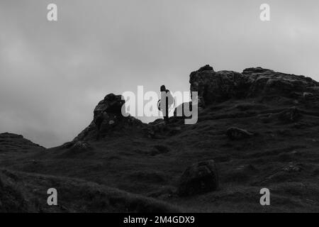 Isle of Skye, Schottland, Vereinigtes Königreich. 24.. Okt. 2021. Eine Person mit einer Boris-Johnson-Maske und eine andere mit einem Öltank als Kopf, die Ölfirmen repräsentiert, benutzt einen Flammenwerfer, um einen Baum zu verbrennen, der den letzten Baum auf Erden darstellt. Dieser theatralische Protest wurde von Ocean Rebellion, einer Schwesterbewegung des Aussterbens Rebellion, im Old man of Storr auf der schottischen Isle of Skye vor dem Start der COP 26 in Glasgow inszeniert. Stockfoto