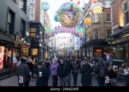 London, UK, 20. Dezember 2022: Die Carnaby Street in Soho bietet Shopping-Fans vor Weihnachten ein mildes und trockenes Wetter. Über der Fußgängerzone hängen aufwendige Dekorationen, aber an einigen Tagen wurden die Fußgänger durch Zugstreiks verringert. Anna Watson/Alamy Live News Stockfoto