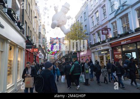 London, UK, 20. Dezember 2022: Die Carnaby Street in Soho bietet Shopping-Fans vor Weihnachten ein mildes und trockenes Wetter. Über der Fußgängerzone hängen aufwendige Dekorationen, aber an einigen Tagen wurden die Fußgänger durch Zugstreiks verringert. Anna Watson/Alamy Live News Stockfoto