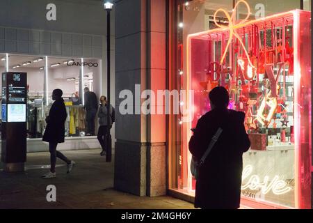 London, UK, 20. Dezember 2022: Besucher genießen mildes und trockenes Wetter vor Weihnachten auf der King's Road in Chelsea. Aufwändige Weihnachtslichter und Dekorationen heben sich in der Dämmerung hervor, aber an einigen Tagen wurde der Fußabdruck durch Zugstreiks verringert. Anna Watson/Alamy Live News Stockfoto