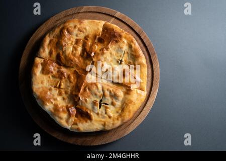 Blick von oben auf traditionelles georgianisches Brot Khachapuri mit Füllung auf Holzbrett Stockfoto