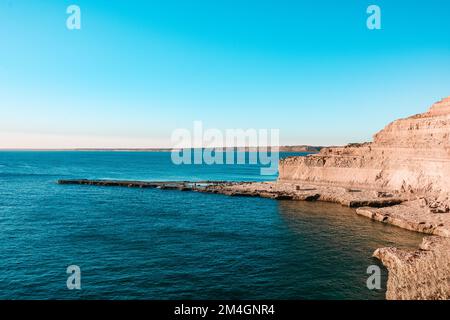 Wunderschöne Landschaft mit felsigen Klippen mit Seelöwen bei Sonnenuntergang auf der Halbinsel Valdes, einem Naturschutzgebiet der patagonischen Küste Argentiniens. Stockfoto