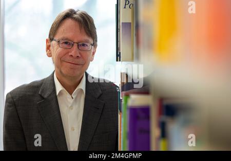 Trier, Deutschland. 21.. Dezember 2022. Uwe Jun, ein Politikwissenschaftler aus Trier, steht vor einem Bücherregal in seinem Büro an der Universität Trier. Außerdem ist er Direktor eines neuen Instituts für Demokratie und Parteiforschung an der Universität Trier. Kredit: Harald Tittel/dpa/Alamy Live News Stockfoto