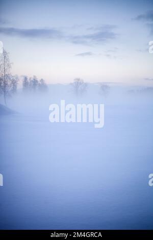 Wunderschöner nebiger Sonnenuntergang im Winterwunderland Finnland Stockfoto