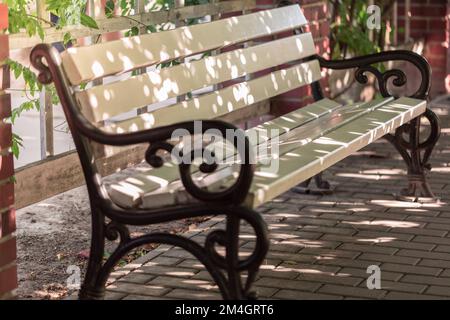 Leere Bank im Park, ein freier Platz zum Ausruhen. Stockfoto