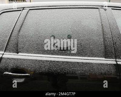 Smiley im Schnee auf dem Autofenster Stockfoto