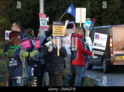 Krankenschwestern und Unterstützer außerhalb des Allgemeinen Krankenhauses Kettering streiken zum zweiten Mal innerhalb einer Woche, da die Gespräche nach der Forderung nach einem Lohnanstieg von 19% weitergehen. Die Streikenden hier wurden heute aus Respekt vor der NHS-Schwester Anju Asok, die zusammen mit Sohn Jeeva Saju und Tochter Janvi Saju letzte Woche ermordet wurde, gedämpft. Anju arbeitet seit letztem Jahr im Kettering General Hospital, und ihre Kollegen haben einen Erinnerungstisch mit einer Kerze und Blumen für sie nahe der Streikpostenlinie. Das RCN (Royal College of Nursing) nannte die Streikaktion. Stockfoto