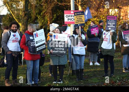 Krankenschwestern und Unterstützer außerhalb des Allgemeinen Krankenhauses Kettering streiken zum zweiten Mal innerhalb einer Woche, da die Gespräche nach der Forderung nach einem Lohnanstieg von 19% weitergehen. Die Streikenden hier wurden heute aus Respekt vor der NHS-Schwester Anju Asok, die zusammen mit Sohn Jeeva Saju und Tochter Janvi Saju letzte Woche ermordet wurde, gedämpft. Anju arbeitet seit letztem Jahr im Kettering General Hospital, und ihre Kollegen haben einen Erinnerungstisch mit einer Kerze und Blumen für sie nahe der Streikpostenlinie. Das RCN (Royal College of Nursing) nannte die Streikaktion. Stockfoto