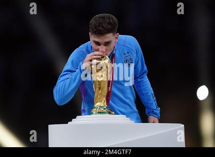 Dateifoto von 18-12-2022 von Argentiniens Julian Alvarez küsst die Trophäe der FIFA-Weltmeisterschaft. Pep Guardiola, Chef von Manchester City, gratuliert dem Stürmer Julian Alvarez zu seinem Erfolg bei der Fußballweltmeisterschaft in Argentinien. Ausgabedatum: Mittwoch, 21. Dezember 2022. Stockfoto