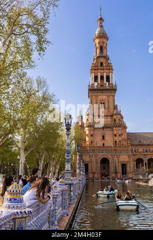 Torre Norte (Nordturm), Plaza de Espana, mit Kanal, Booten, Touristen und Maria Luisa Park im Hintergrund. Sevilla, Andalusien, Spanien. Stockfoto