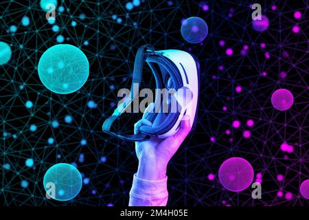 Die Handhülle eines Mannes bietet Platz für das VR-Headset. Schwarzer Hintergrund mit abstraktem Gitter und Kugeln in Neon. Das Konzept von Metaverse, Cyberspace und Wissenschaft. Stockfoto