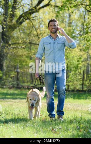 Ein Mann, der auf seinem CP mit seinem Hund spaziert Stockfoto