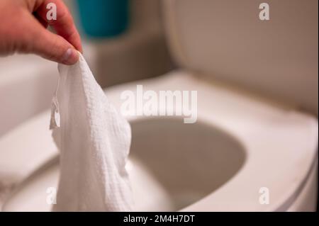 Einweg-Wischtücher werden auf der Toilette heruntergespült, wo sie Verstopfung und Probleme mit der Abwasserbehandlung verursachen können. Stockfoto