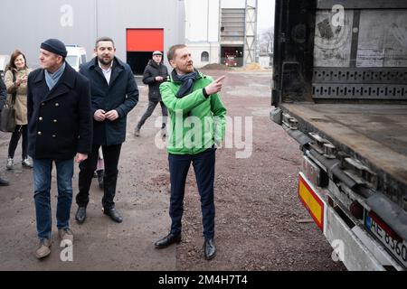 Dresden, Deutschland. 21.. Dezember 2022. Michael Kretschmer (CDU, r), Ministerpräsident von Sachsen, steht vor einem Lkw anlässlich des Ladens von Medikamenten und Notstromgeneratoren für die Ukraine. Die Hilfslieferung geht an acht ukrainische Städte, von denen sieben bereits eine Zwillingsstadt in Sachsen haben. Kredit: Sebastian Kahnert/dpa/Alamy Live News Stockfoto