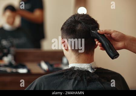 Friseur rasierender Weißer im Friseursalon Stockfoto