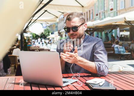 Mann, der per Videoanruf mit seinem Laptop chattet. Stockfoto