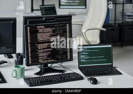Horizontales Bild von Computermonitoren mit Programmcodes auf Bildschirmen in modernen Büros Stockfoto