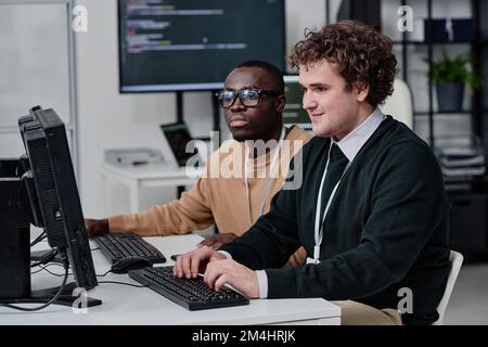 Zwei IT-Spezialisten arbeiten bei der Teamarbeit im Büro mit Computercodes für neue Software auf dem Computer zusammen Stockfoto