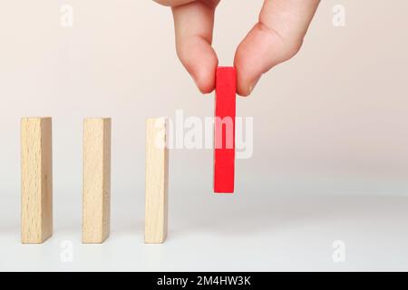 Ein Geschäftskonzept mit Dominoeffekt. Die Hand legt Dominosteine, um eine Kettenreaktion zu erzeugen Stockfoto