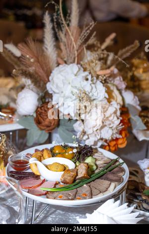 Fleischstücke von Pferdefleisch, Rindfleisch und Huhn auf dem Tisch im Restaurant. Stockfoto