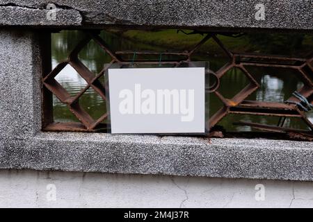 Ein leeres, weiß laminiertes Schild, das an einer Brücke angebracht ist Stockfoto