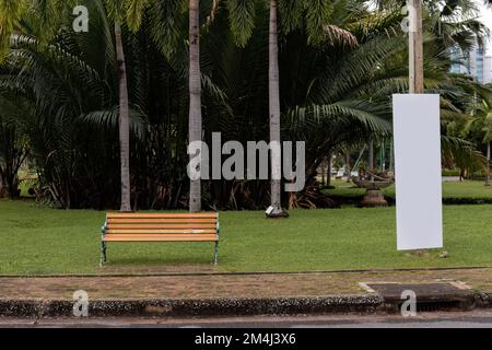 Hohes, leeres weißes Schild neben einer Bank in einem Park Stockfoto