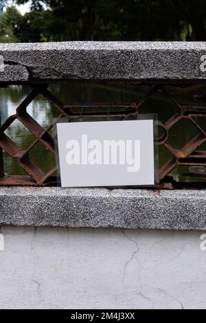 Ein leeres, weiß laminiertes Schild, das an einer Brücke angebracht ist Stockfoto