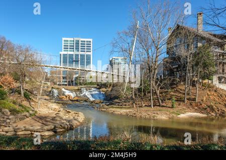 Falls Park on the Reedy mit Blick auf die Liberty Bridge und die Gebäude im Stadtzentrum von Greenville, South Carolina. Stockfoto