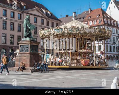 Statue de Johannes Gutenberg und neben ihm das Kindermuseum Karussell Merry umrunden Gutenberg am Place Gutenberg, Straßburg, Departement Stockfoto