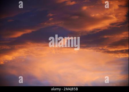 Sonnenaufgang mit einem Himmel voller wunderschöner Wolken mit Blau- und Orangenfarben, die einen Wirbel bilden Stockfoto