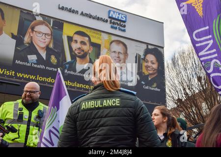 Krankenwagenpersonal steht vor der Unison (Public Service Union)-Tafel vor dem Londoner Ambulance Service Hauptquartier, während Tausende von Krankenwagen und Sanitätern ihren Streik in einem Streit über Lohn und Arbeitsbedingungen beginnen. Stockfoto