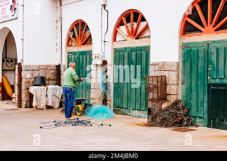 Fischer, die Netze reparieren. Fischereihafen Tazone. Tazone, Fürstentum Asturien, Spanien, Europa Stockfoto