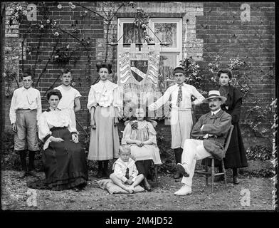 Ein Foto einer edwardianischen oder viktorianischen Schule, auf dem Lehrer und einige Schüler vor einem Banner gezeigt werden, das Mileham Elementary Schools Challenge Tropy 1905 liest. Geburtsdatum: 1908. Digitalisierte Archivkopie eines Original-Ganzplattenglasnegativs. Stockfoto