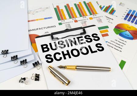 Geschäftskonzept. Auf der Tabelle unter Finanzdiagrammen und -Diagrammen befindet sich ein Tablet mit der Aufschrift "Business Schools" Stockfoto