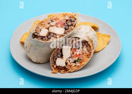 Mexikanischer Rindfleischburrito auf einem kleinen Teller mit Chips Nachos auf dem Teller Stockfoto