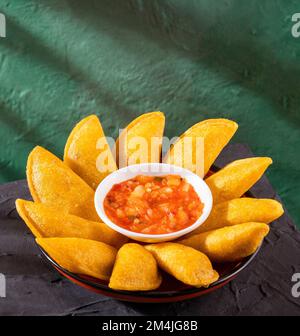 Kolumbianische gebratene Empanadas gefüllt mit Fleisch - heiße Sauce Stockfoto