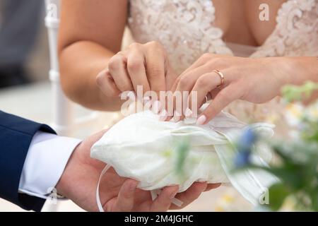 Nahaufnahme der Hände der Braut während der Hochzeit, während sie den Ehering für den Austausch der Ringe nehmen Stockfoto